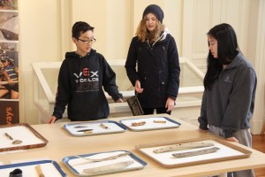 Students looking at Inuit tools such as snow goggles and crampons for the feet