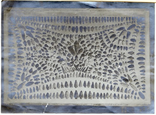 Black and white photograph of of American Indian artifacts arranged into a pattern