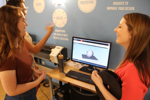 Image of Claudia Wessner with Phillips Academy students looking at a 3D image of Homo naledi's skull on the computer.