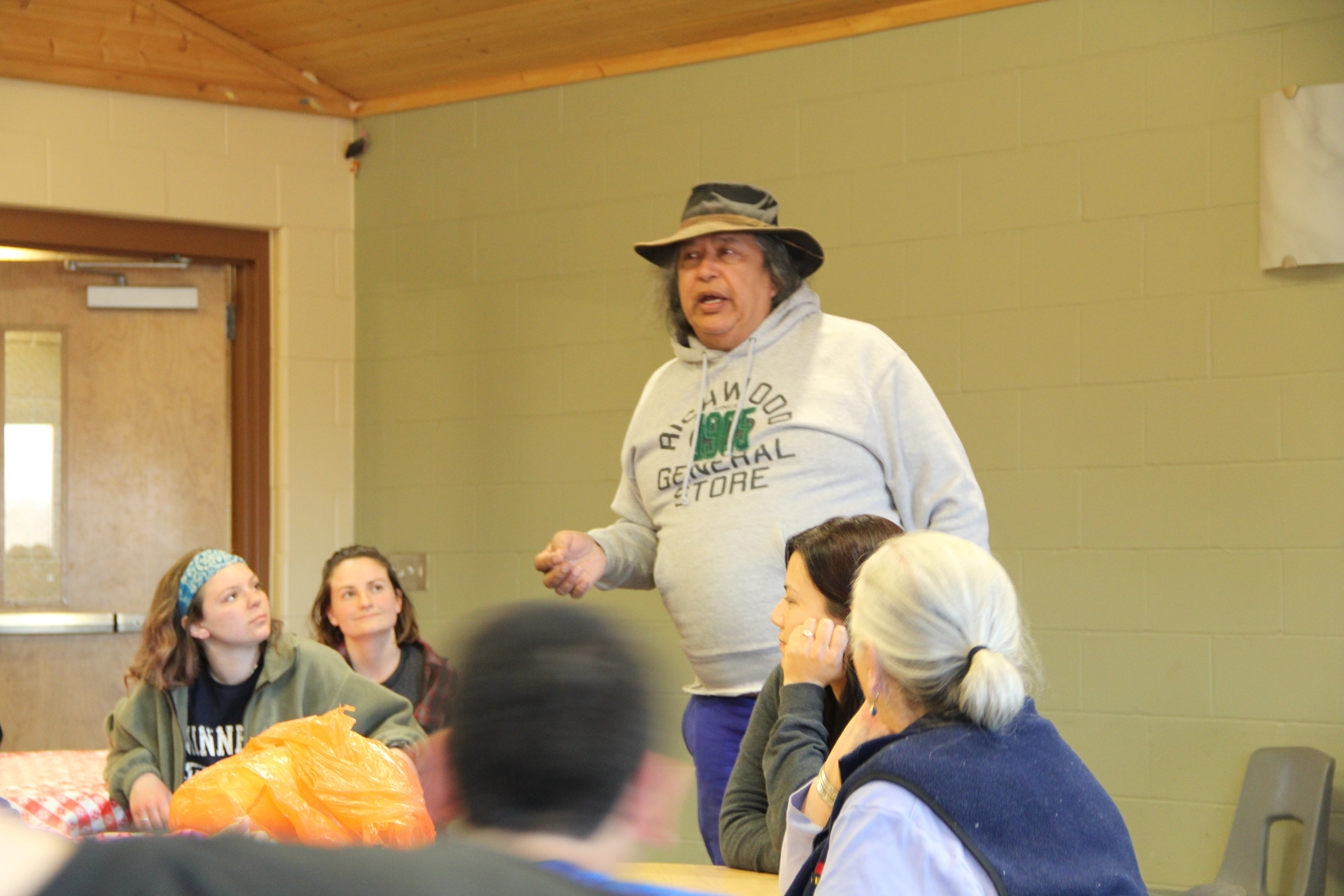 Image of White Earth Land Recovery Project Executive Director Bob Shimek talking to tribal members and college service learning students, March 2016.