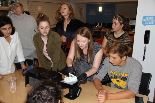 Image of students and Makerspace guru Claudia Wessner with 3D print of Homo naledi hand.