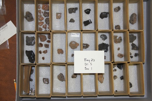 These artifacts have been rehoused and placed in a gray archival box rather than the original wooden drawer.