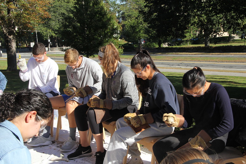 Image of students flint knapping or making stone tools.