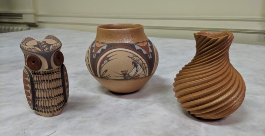 Three pottery figures and vessels, including painted owl figurine, the collaborative piece by Dominique and Maxine, and a swirl pot by Dominique.