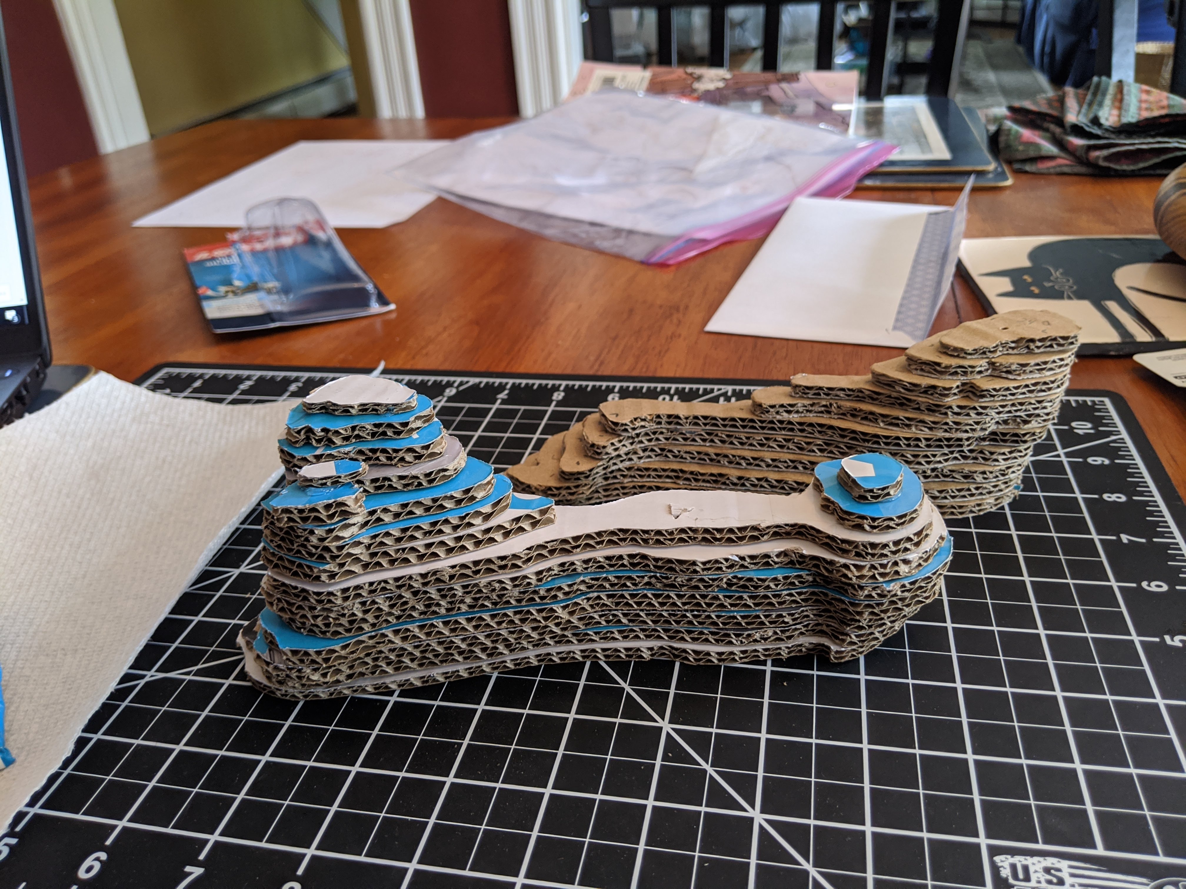 Image of the partially assembled cardboard bone model on a black cutting mat.